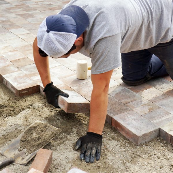 Worker,Setting,Paver,Bricks,On,Large,Patio,,Paving,Backyard
